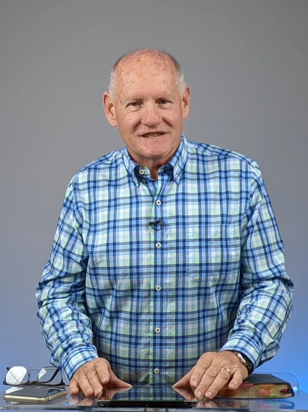 Pastor Shayne Cunningham, Senior Pastor of CoastWIDE Church, smiling in a blue check shirt